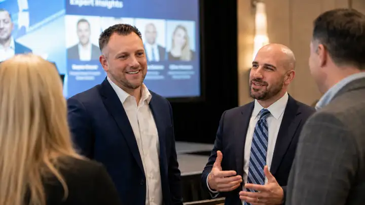 Alysis team members in conversation at a conference